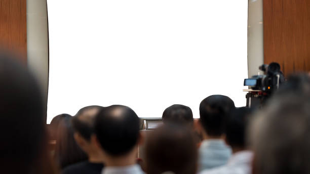 istock Front view of mockup on blank white screen with space in conference room and audiences 2054962616