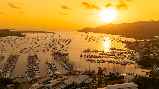 Captured From Above,the Harbor Exudes a Serene Charm,with Boats Peacefully Moored against the Idyllic Ocean Backdrop,Bathed in the Warm Hues of the Orange Sky during Sunset,a Breathtaking Vista that Epitomizes Coastal Tranquility and Natural Splendor.