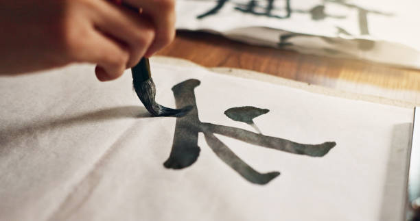 istock Hands, brush for writing and ancient font for art and script, calligraphy and closeup with alphabet. Japanese, creativity and vintage tools, paintbrush and person stroke with traditional stationery 2054972724