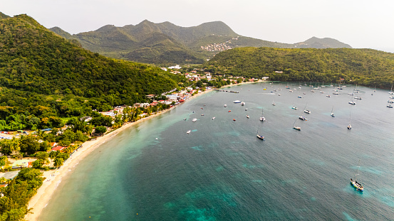 Aerial View Captures Boats Sailing Gracefully in the Sea,their Journey Accentuated by the Lush Greenery of Mountains Adorning the Nearby Beach,a Harmonious Blend of Maritime Adventure and Natural Splendor Set against the Tranquil Backdrop of the Coastline.