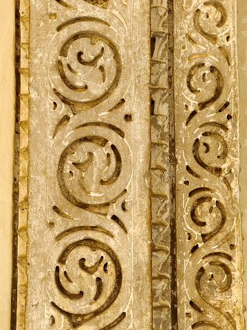Stone carving detail with floral pattern on a historic building's facade.