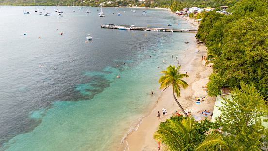 A colorful tropical island scene in the Philippines, with a traditional wooden outrigger bangka boat on a white beach in Occidental Mindoro Province.