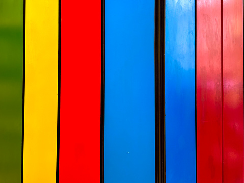 Vibrant multicolored wooden planks in a row, creating a colorful abstract background.