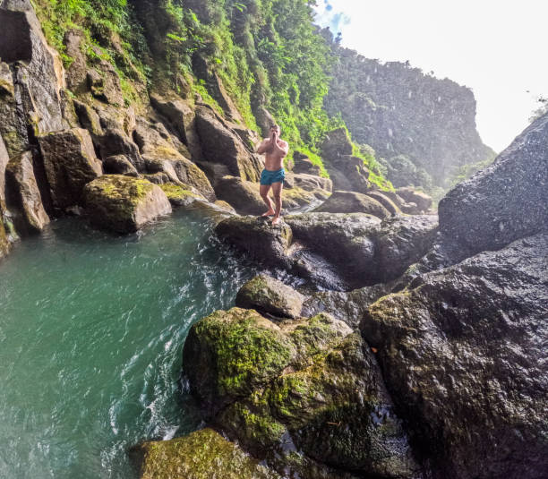 istock Shirtless Young Man Standing on Rock by Stream at Mountain during Sunny Day 2055009357