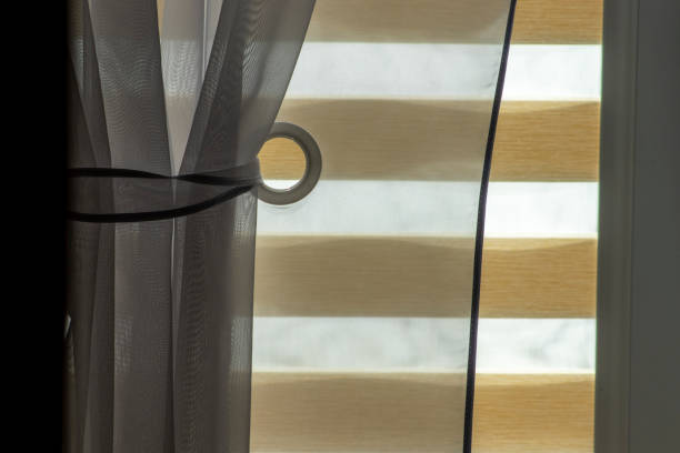 istock Brightly lit interior with a window dressed with beautiful curtains and roller blind. 2055022350