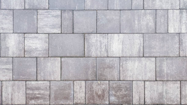 istock Close-up surface of gray paving stones road texture background. 2055022410