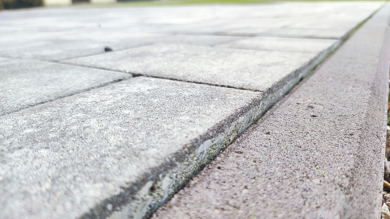 Detailed texture of uniformly paved grey bricks in a surface road.
