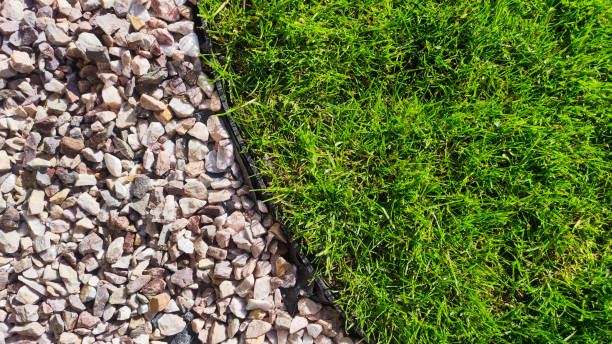 istock Lush green lawn with garden edge and decorative stones. 2055022607