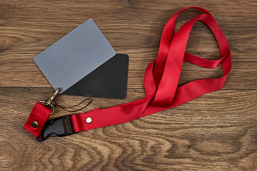 Grey card with a red strap on wood table, a photographer’s tool, determining the correct white balance