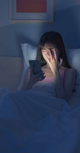 istock Asian woman scroll smartphone dark 2055027584