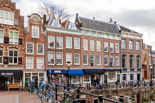 Utrecht, The Netherlands - March 1st, 2024: Tourists walk along the traditional old street in Utrecht, Netherlands.