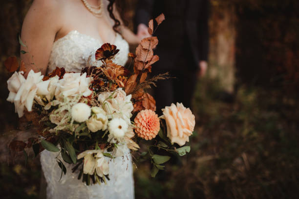 istock Bride and groom with autumn colored wedding bouquet 2055064059