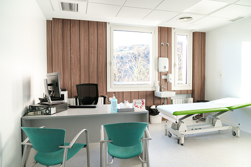 Bright clinic room with wooden accents and medical equipment.