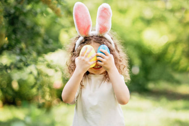 istock Baby with basket full of colorful eggs. Easter egg hunt. 2055122216