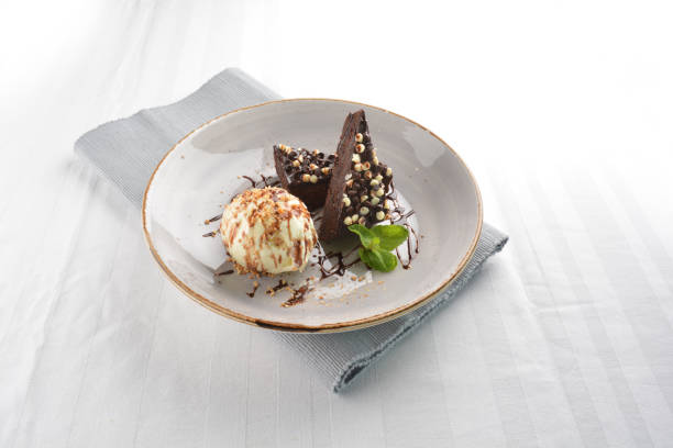 istock walnut chocolate brownie with vanilla ice cream and peanut, chocolate sauce, mint leaf dessert in round plate on white table western asian cafe halal dessert restaurant pastry menu 2055133304