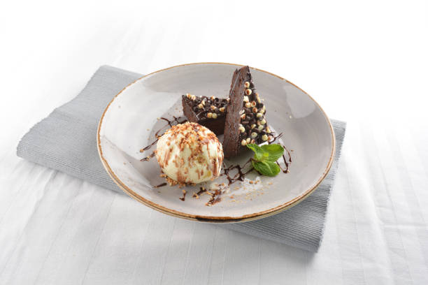 istock walnut chocolate brownie with vanilla ice cream and peanut, chocolate sauce, mint leaf dessert in round plate on white table western asian cafe halal dessert restaurant pastry menu 2055133312