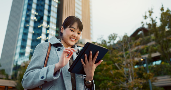 Happy asian woman, tablet and city for social media, research or communication in outdoor networking. Business female person smile on technology in online search, chatting or texting in an urban town