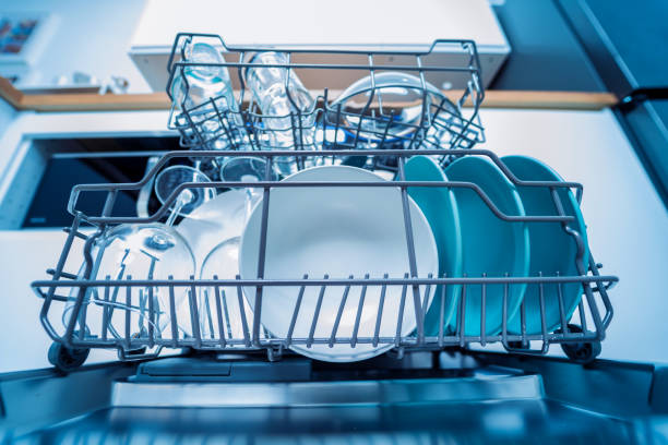 istock The white kitchen and opened dishwasher with clean dishes 2055157002