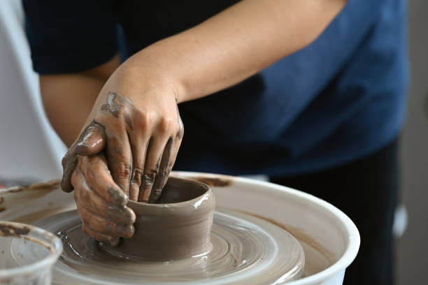 istock The potter's hands working on the potter's wheel, making a cup from clay. 2055283533