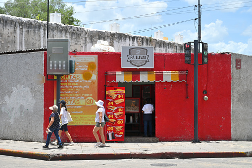 Merida, Mexico - July 20, 2023: Unidentified people at colorful colonial style buildings at street of Merida city old town, Yucatan, Mexico