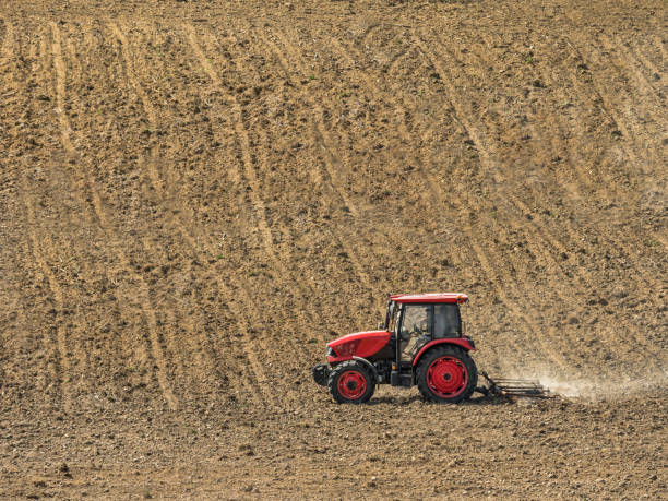 istock Farm tractor harrowing arable field 2055287829