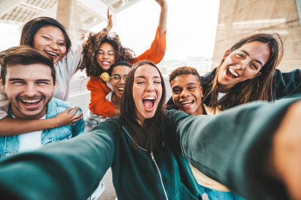 happy multi ethnic young people taking selfie photo with smart mobile phone outside - life style concept with guys and girls having fun hanging out on city street - youth community concept - mobile phone group of people human face latin american and hispanic ethnicity - fotografias e filmes do acervo