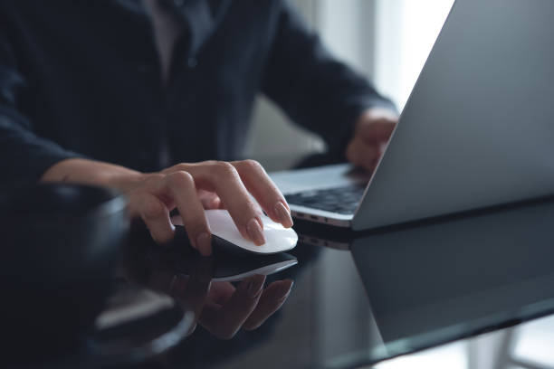 istock Woman hand clicking computer mouse on office table. Business woman working on laptop computer and using wireless mouse, browsing the internet, searching the information, internet global networking concept 2055328072