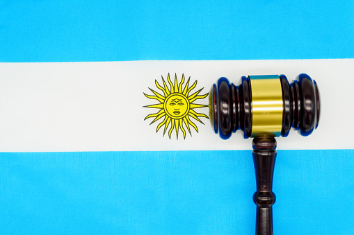 Symbol of justice and the Argentine legal system, represented by a gavel and the national flag