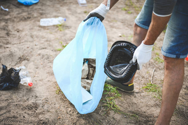 male volunteer collecting garbage in the forest