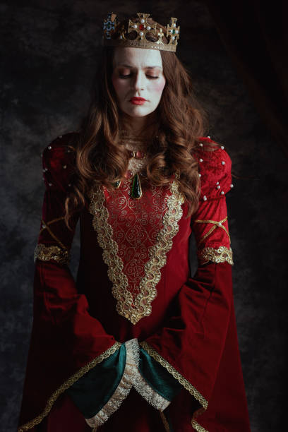 istock medieval queen in red dress with white makeup and crown 2055421276