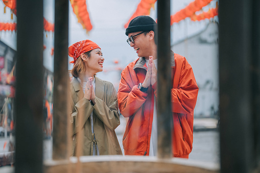 Asian Chinese couple tourist praying in front of Chinese temple in Penang island during chinese new year chap goh meh