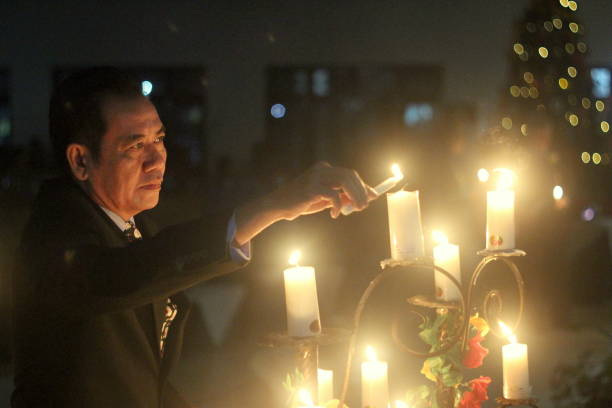 Palangka Raya City, Central Kalimantan Province, Indonesia - December 12, 2012 - An Asian man lights candles during a Christmas celebration in Palangka Raya City.