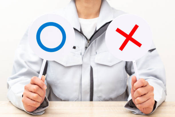 istock A woman answers using circle and cross placards. 2055478792