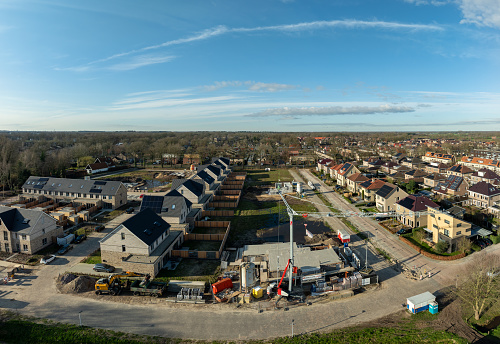 Oldenzaal, Netherlands - March 2, 2024: Aerial shot of a constructioin site with large crane in a residential area