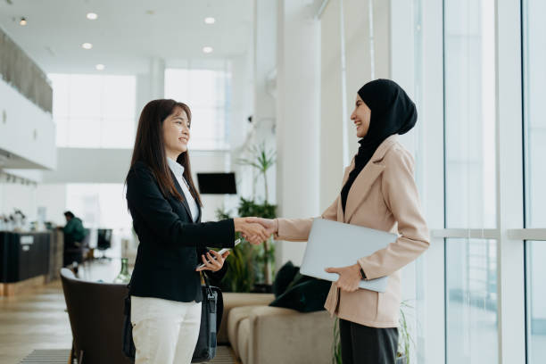 Businesswomen shake hands in office