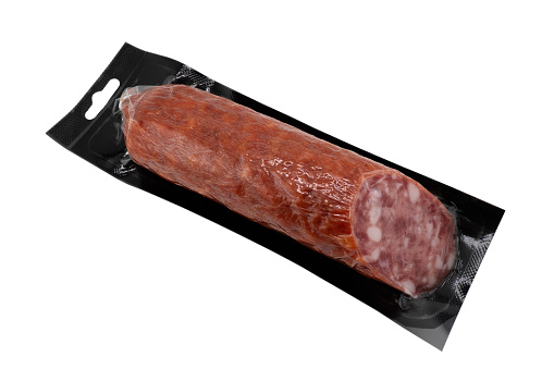Top view of smoked meat salami in vacuum package isolated on black background. Raw smoked salami sausage isolated