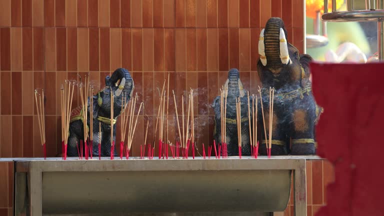 Burning incense sticks in front of deities