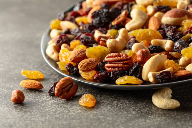 istock Mix of dried nuts and raisins on a rustic background. 2055572599