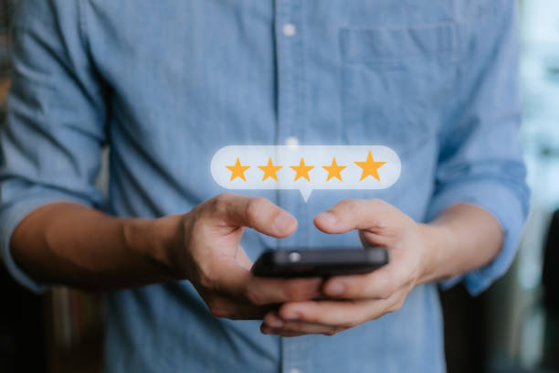 istock Close up Man hand using smartphone with popup five star icon for feedback review satisfaction service, Customer service experience and business satisfaction survey. 2055573906