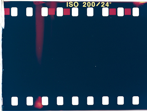 Background of an old analog camera film with noise and overexposure and elements of old photos. Light leak and film strip