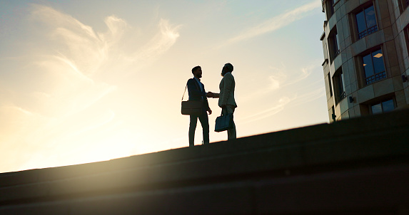 Business people, handshake and city silhouette for partnership, outdoor introduction and travel meeting. Corporate clients or men shaking hands for welcome, hello and agreement or career opportunity