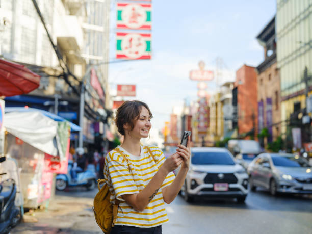 istock Woman using smartphone while walking in Chinatown in Bangkok 2055649365