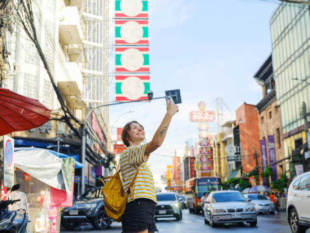 istock Woman using smartphone while walking in Chinatown in Bangkok 2055654511