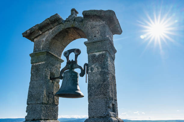 Medieval bell tower on blue sky background and radiant sun on a sunny day, Trujillo
