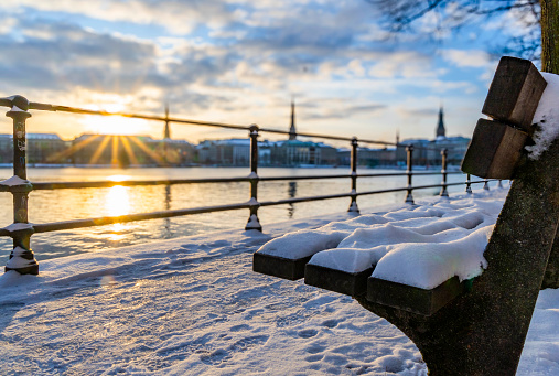 Snow-covered park bench at Ballindamm in Hamburg
