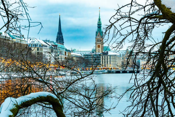 View through snow-covered branches of the Christmas-decorated Ballindamm View through snow-covered branches of the Christmas-decorated Ballindamm and the Alster in Hamburg, horizontal sterne stock pictures, royalty-free photos & images