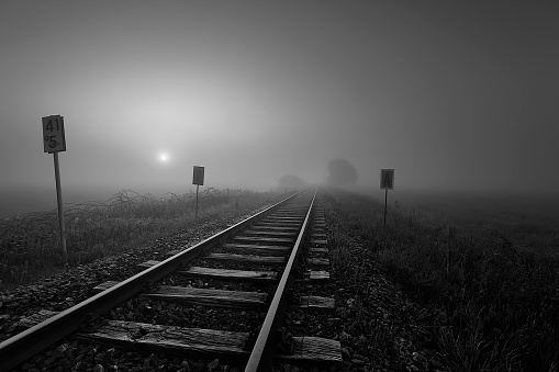 a train tracks with fog in the background