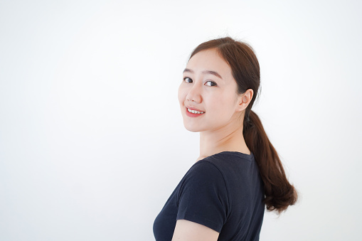 Smart and good looking Asian beautiful young woman in dark blue color t-shirt standing for portrait photography on white background and poses to camera. Asian young woman portrait.