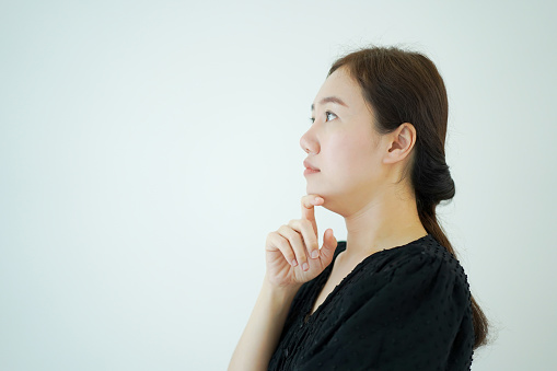 Smart - good looking Asian young adult woman in black shirt portrait standing in front of the white background. beautiful Asian woman portrait on white background.