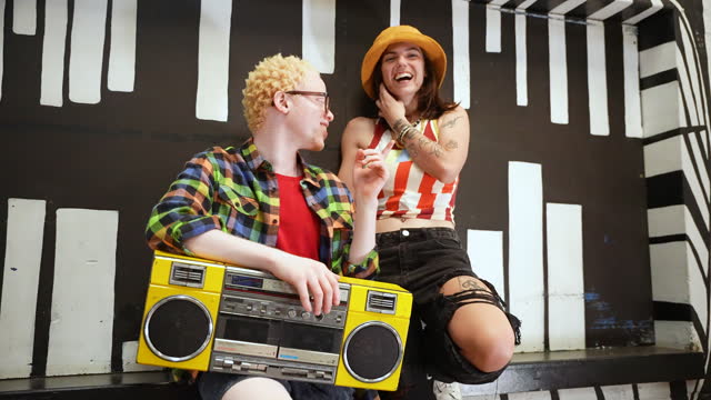 Happy friends with boom box talking and laughing